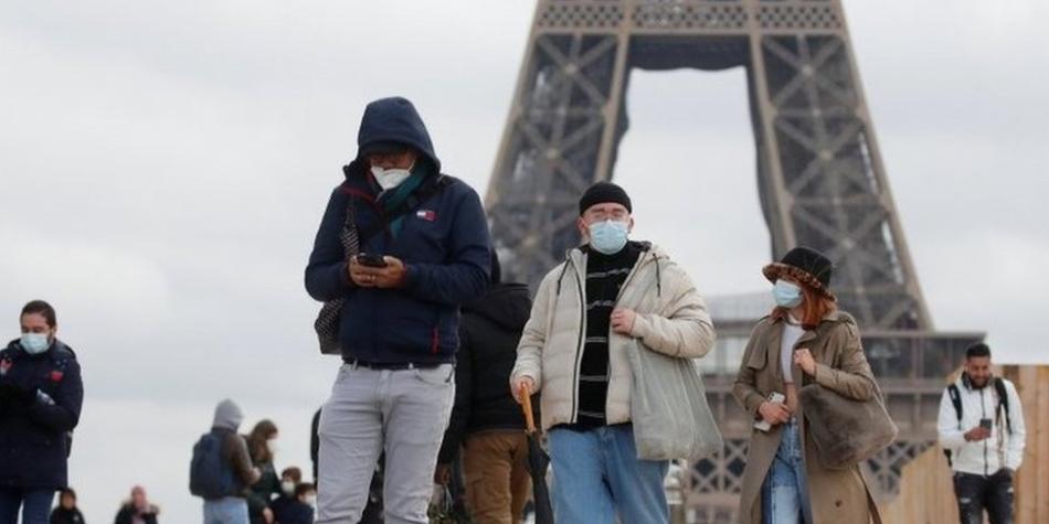 BBC Mundo: Personas, con mascarillas protectoras, caminan por la plaza Trocadero, cerca de la Torre Eiffel en París.