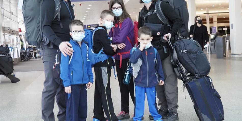 BBC Mundo: La familia posa junta para una foto en un aeropuerto.