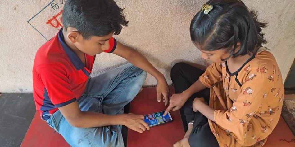 BBC Mundo: Dos niiños juegan con un teléfono móvil.